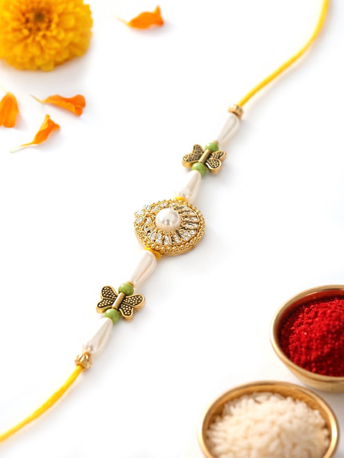 KARATCART Gold Plated White Pearl and Butterfly Charm Bhaiya Rakhi with Roli & Chawal