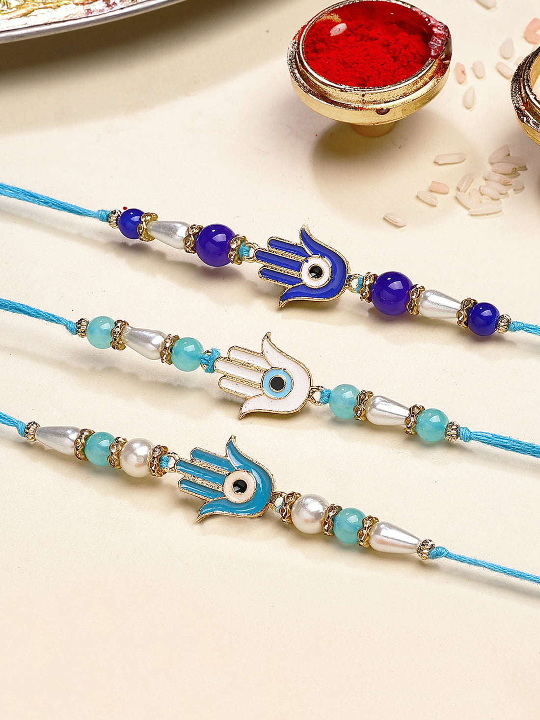 Karatcart Set of 3 White and Blue Enamel Hamsa Hand Evil Eye Rakhi for Brother with Roli & Chawal