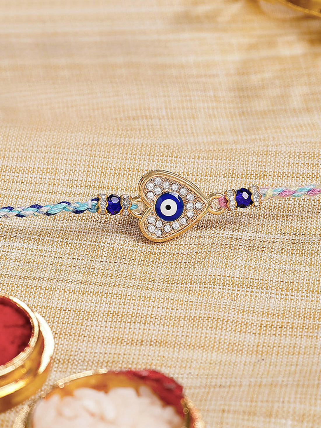 Karatcart Gold Plated Blue American Diamond Heart Shape Evil Eye Bhiya Rakhi with Roli & Chawal