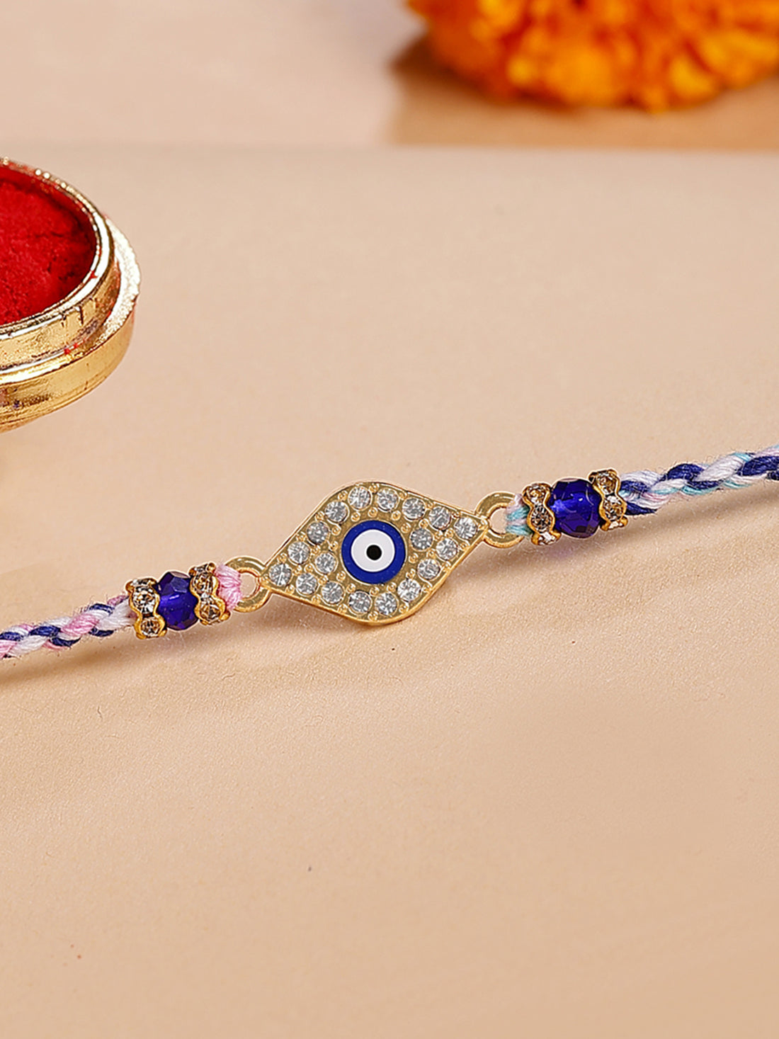 Karatcart Gold Plated Blue American Diamond Diamond Shape Evil Eye Bhiya Rakhi with Roli & Chawal