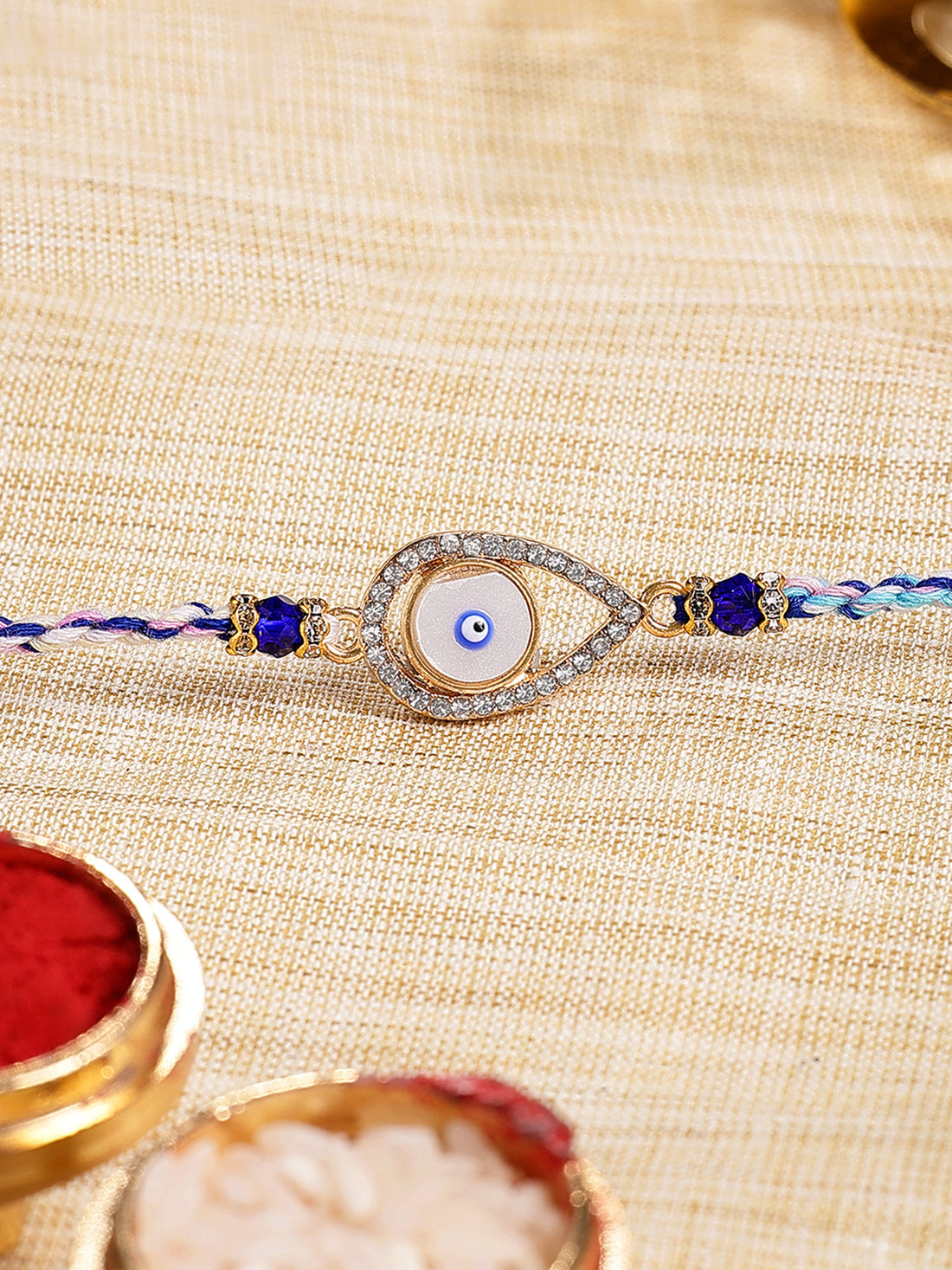 Karatcart Gold Plated White American Diamond Drop Shape Evil Eye Bhiya Rakhi with Roli & Chawal