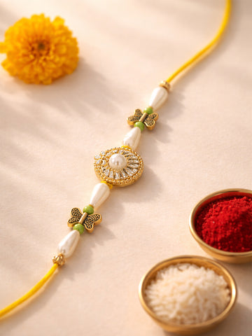 KARATCART Gold Plated White Pearl and Butterfly Charm Bhaiya Rakhi with Roli & Chawal