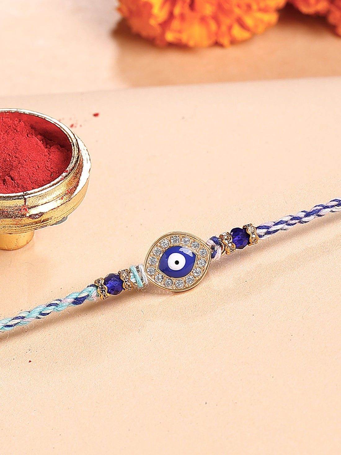 Karatcart Gold Plated Blue Evil Eye and American Diamond Bhiya Rakhi with Roli & Chawal